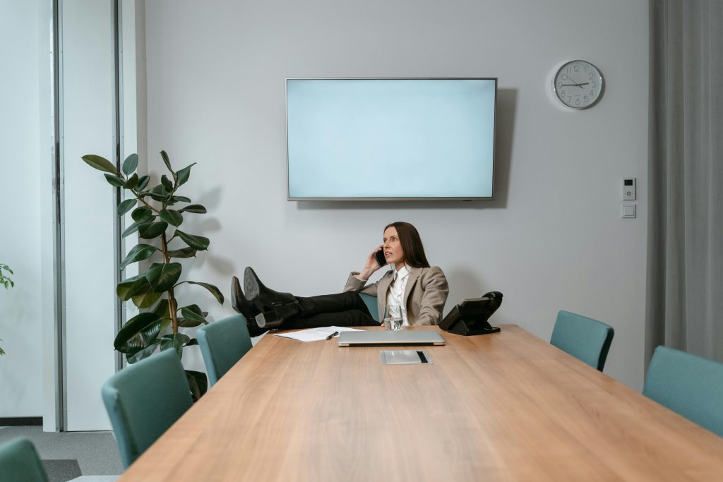 Businesswoman Talking on the phone while relaxing and reclining in an office chair in a meeting room